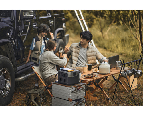 Camping familial avec station d''alimentation portable, table et accessoires à côté d''un véhicule tout-terrain