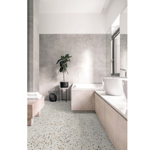 Salle de bain claire avec sol en terrazzo, baignoire, lavabo et plante