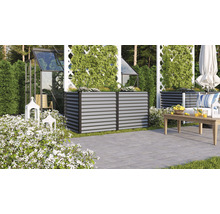 Ambiance de jardin avec des parterres de fleurs surélevés en métal, une serre et un coin salon