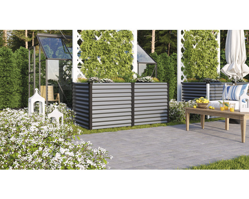 Ambiance de jardin avec des parterres de fleurs surélevés en métal, une serre et un coin salon