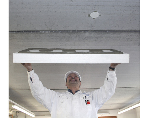 Un artisan fixe un panneau isolant au plafond