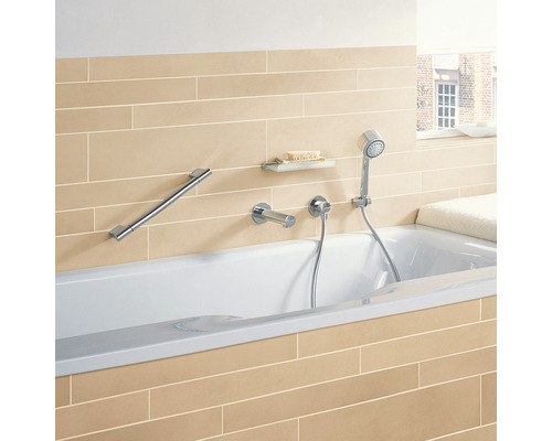 Badezimmer mit Badewanne, Haltegriff, Seifenablage, Brausegarnitur und Fliesen