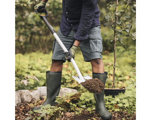 Eine Person gräbt mit einem Spaten im Garten ein Loch.