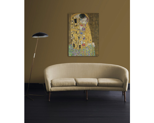 Gemälde Die Liebenden von Gustav Klimt an der Wand über einem Sofa
