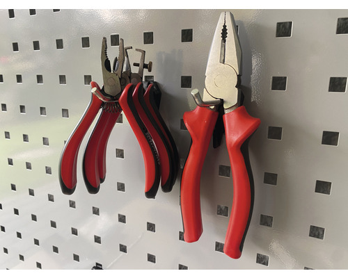 Deux pinces avec des poignées sont suspendues à un panneau perforé.