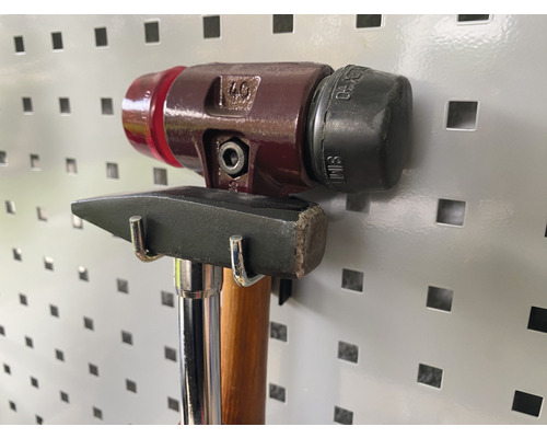 Zwei Hämmer hängen an einer Werkzeugwand.