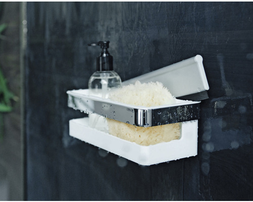 Doppelter Duschkorb mit Seife, Duschgel und Schwämmen an einer dunklen Wand