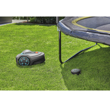 Gardena Mähroboter mit Ladestation auf Rasenfläche unter Trampolin
