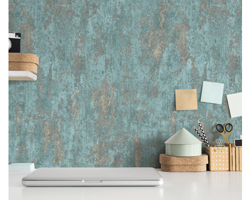 Scène avec un papier peint structuré, un ordinateur portable et des articles de bureau sur un bureau blanc.