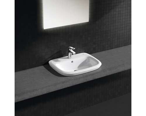 Keramikwaschbecken mit Armatur auf Ablagefläche im Badezimmer