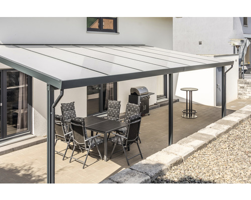 Terrassenüberdachung mit Tisch und Stühlen im Außenbereich.