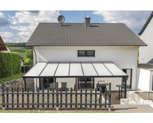 Terrassenüberdachung aus Aluminium an einem Wohnhaus mit Grill und Gartenmöbeln
