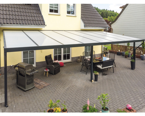 Terrassenüberdachung mit Sitzgruppe und Grill auf gepflasterter Terrasse