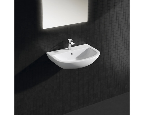 Waschtisch mit Armatur und Spiegel an einer dunklen Wand