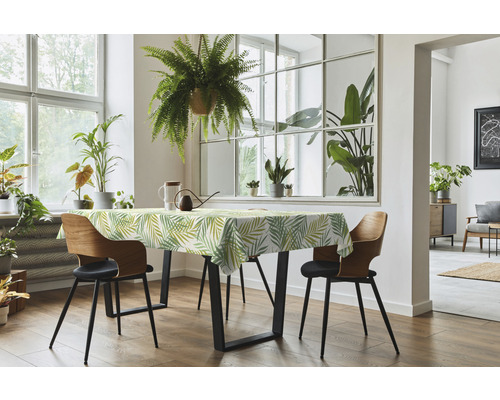 Esstisch mit Tischdecke, Stühlen und Zimmerpflanzen in einem hellen Raum.