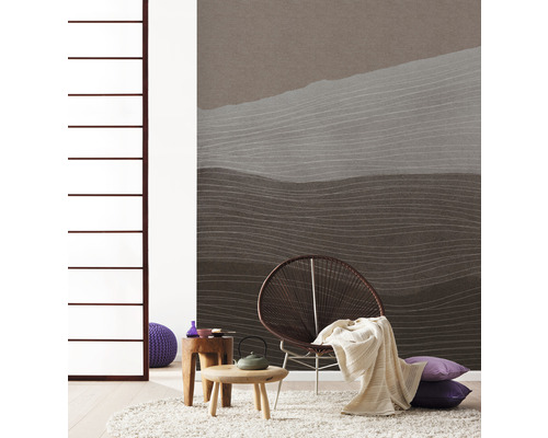 Salon avec papier peint à motifs, fauteuil, tapis et tables d''appoint