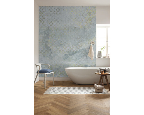 Salle de bains avec baignoire, chaise, tapis, tabouret et papier peint à motifs.