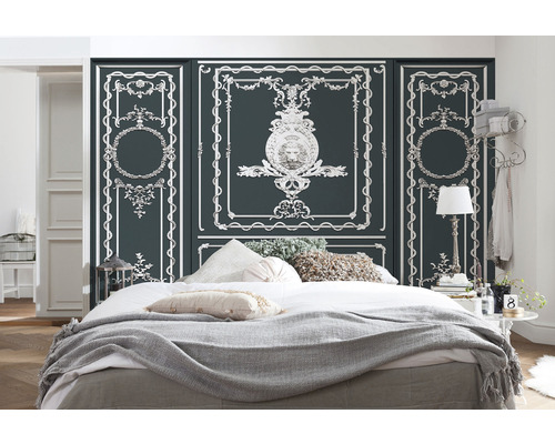 Chambre avec lit, couvertures, coussins et panneaux muraux avec moulures décoratives