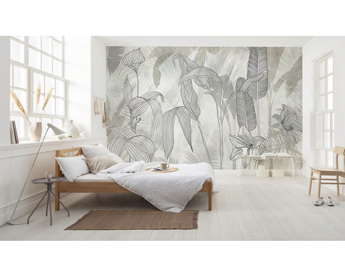 Chambre lumineuse avec un lit et un papier peint à motifs de plantes