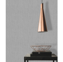 Raumszene mit grauer Tapete, Lampe und Deko auf Tisch