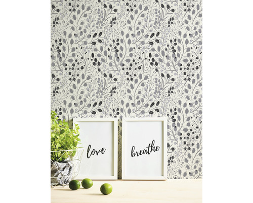 Tapete mit Pflanzenmuster hinter zwei gerahmten Kunstdrucken