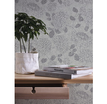Scène avec papier peint à motifs, table, livres et une plante