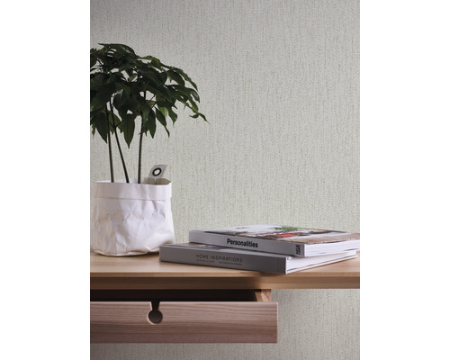 Tapete mit Textiloptik über einem Holztisch mit Zimmerpflanze und Büchern
