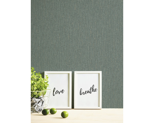 Nahaufnahme einer grauen Textiltapete mit zwei Bildern, einer Pflanze und Limetten