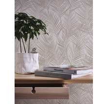 Papier peint décoratif avec motif de palmier dans un salon avec table et plante.