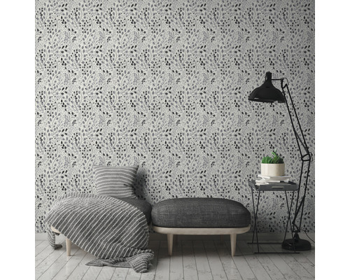 Ein Zimmer mit einer floralen Tapete, einer Bank, einem Sessel, einer Stehlampe und einem Beistelltisch