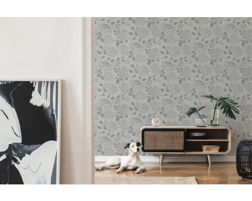 Wohnzimmer mit floral gemusterter Tapete, Kommode und Hund