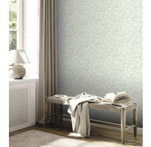 Heller Raum mit floral gemusterter Tapete, Bank und dekorativen Elementen.
