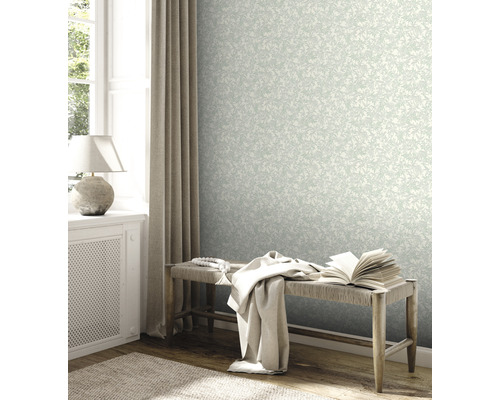 Heller Raum mit floral gemusterter Tapete, Bank und dekorativen Elementen.