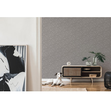 Wohnzimmer mit grauer Mustertapete, Sideboard, Zimmerpflanzen und Hund
