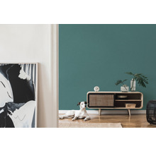 Wohnzimmer mit petrolfarbener Wand, Kommode und Hund
