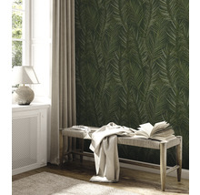 Ein Zimmer mit einer Wandtapete mit Palmenblattmuster, einem Fenster, einem Heizkörper und einer Bank.