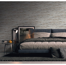 Schlafzimmer mit gemusterter Tapete, Bett, Nachttisch und Teppich