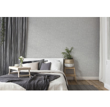 Helles Schlafzimmer mit grauer Textiltapete, Bett und Holzboden