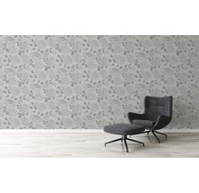 Vue d''une pièce avec du papier peint à motifs floraux et un fauteuil avec repose-pieds