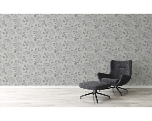 Raumansicht mit Blumentapete und Sessel mit Hocker