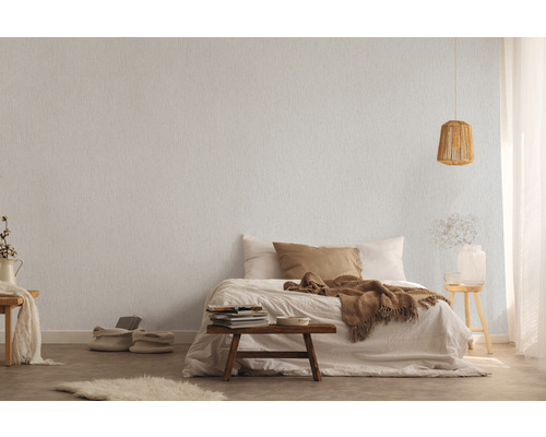 Schlafzimmer mit Bett und gemusterter Tapete für eine warme Atmosphäre