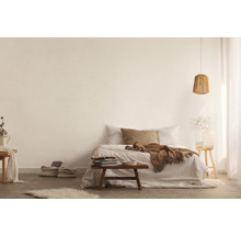 Helles Schlafzimmer mit Bett, Holztisch, Lampe und dekorativen Elementen