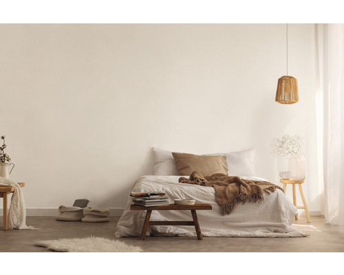 Helles Schlafzimmer mit Bett, Holztisch, Lampe und dekorativen Elementen