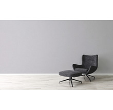 Sessel mit Fußhocker vor einer Wand
