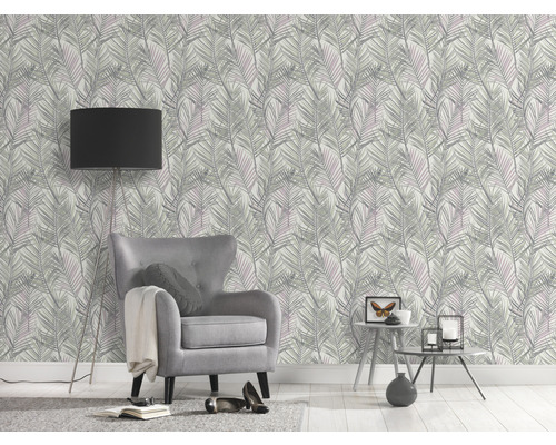 Dekorierter Raum mit Sessel, Stehlampe und Tapete mit Blattmuster