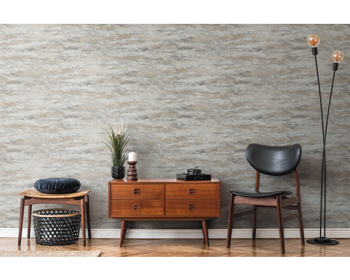 Raumansicht mit gemusterter Tapete, Kommode, Stuhl und Stehlampe