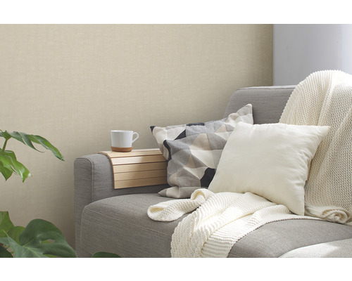 Wohnzimmer mit grauer Couch, Kissen und beiger Tapete