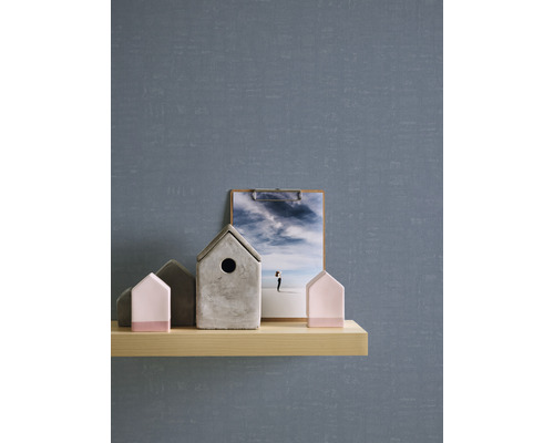 Dekorative Szene mit einer Ablage, auf der sich Deko-Häuser und eine Bildklemme befinden