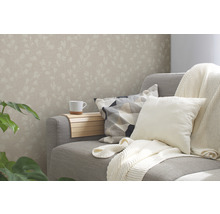 Wohnzimmer mit floral gemusterter Tapete, Sofa, Kissen und Getränkehalter