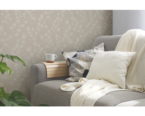 Salon avec papier peint à motifs floraux, canapé, coussins et porte-boissons